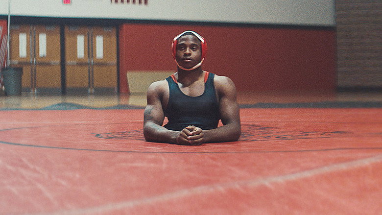 Zion Clark mid-match, his upper body straining against an opponent