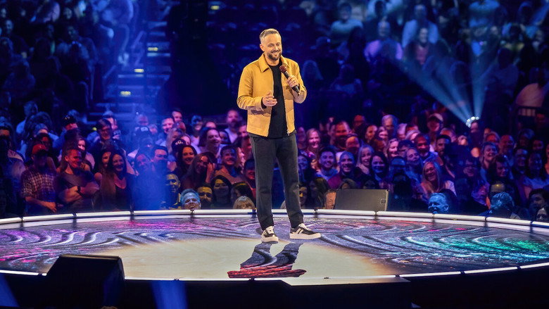 Nate Bargatze on stage, mid-performance, in a large arena setting