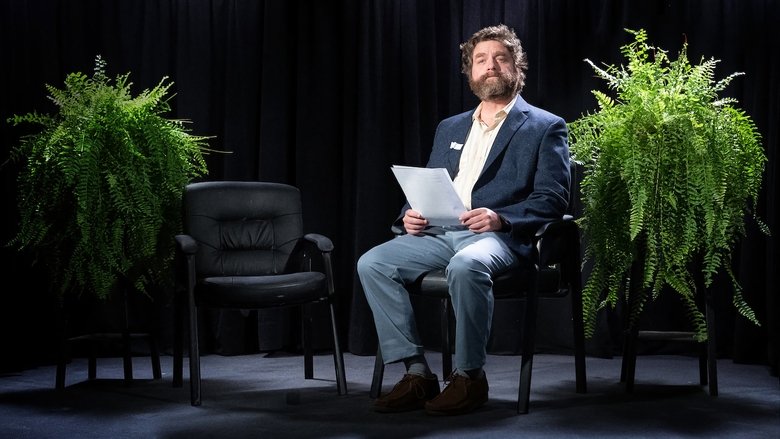 Zach Galifianakis and his crew in a dimly lit motel room, looking exhausted and disheveled