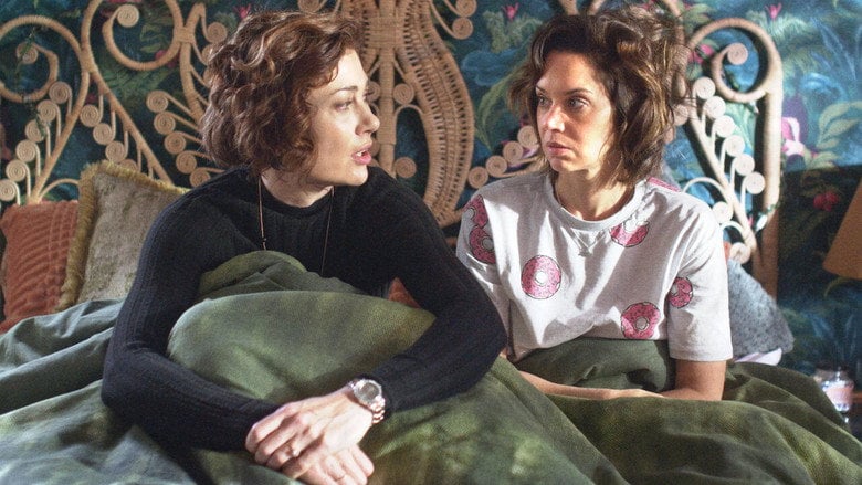 Sondra and Carla mid-argument, their faces flushed with frustration and affection