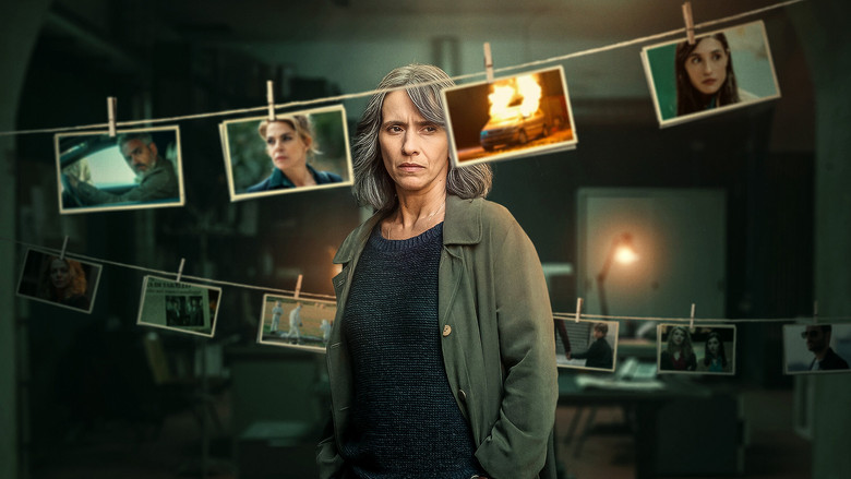 Sara stands in a dimly lit alley, her face half-shadowed, watching something—or someone—just out of frame.