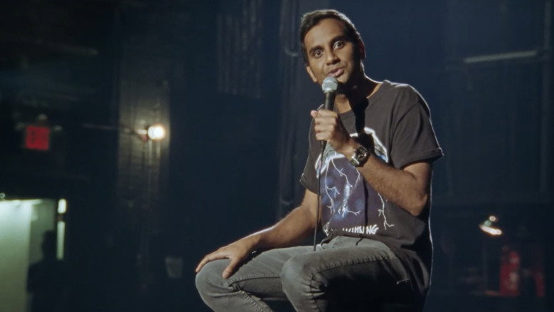 Ansari performing on a warmly lit stage