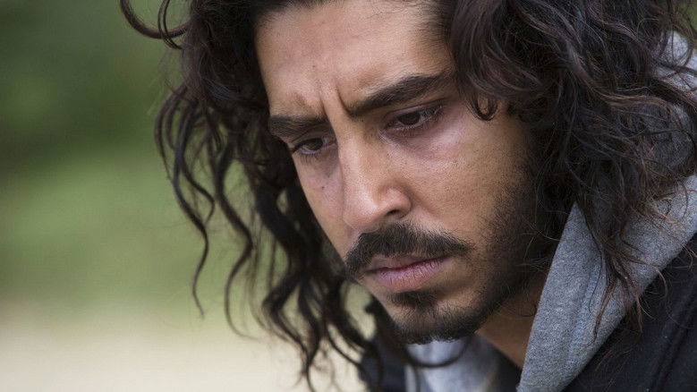 Saroo (Dev Patel) staring intensely at a computer screen while searching for his childhood home on Google Earth