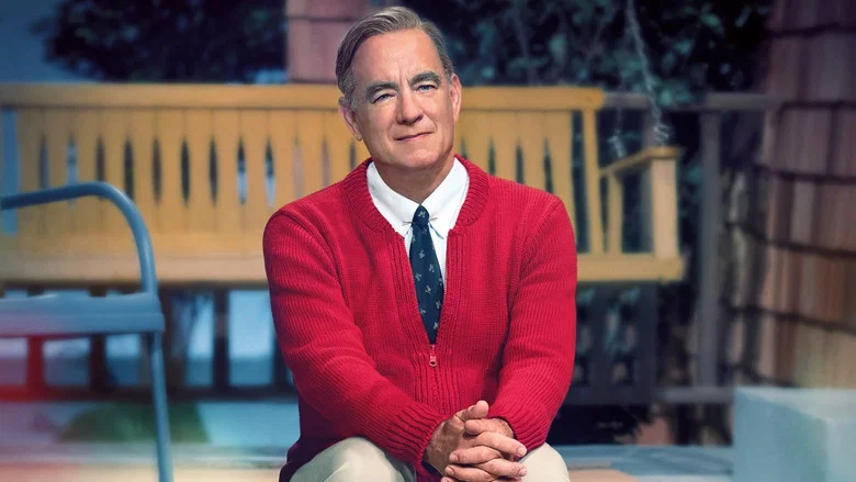 Lloyd Vogel sits across from Fred Rogers in a quiet restaurant booth, the soft light catching the tension in his posture.