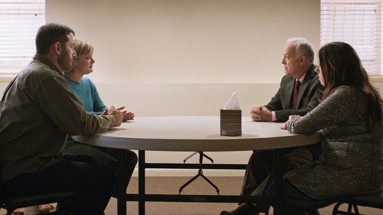 A dimly lit church basement, the kind with fluorescent lighting and folding chairs, where the weight of the conversation hasn’t yet begun.