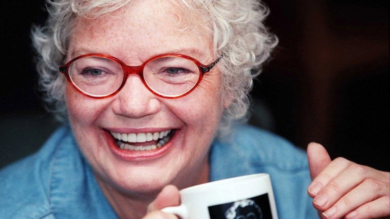 A close-up of Molly Ivins mid-laugh, her flame-red hair catching the light, a cigarette dangling from her fingers as if it’s an extension of her own irreverence.