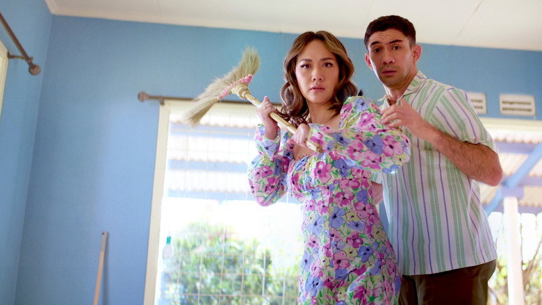 A cramped living room where Adimas and Adelia sit back-to-back on a couch, surrounded by moving boxes and half-unpacked belongings, their expressions a mix of exhaustion and exasperation.