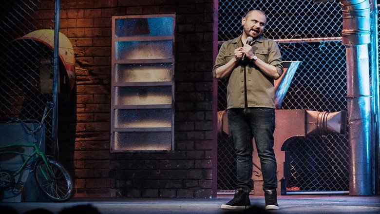 Ricardo Quevedo on stage, mid-laugh, gesturing to the audience