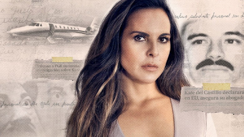 A dimly lit interview setup, Kate del Castillo seated against a dark background, her expression unreadable but her posture tense.