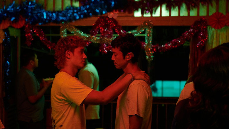 The brothers share a quiet moment in their cramped living space, the warm light filtering through a grimy window.