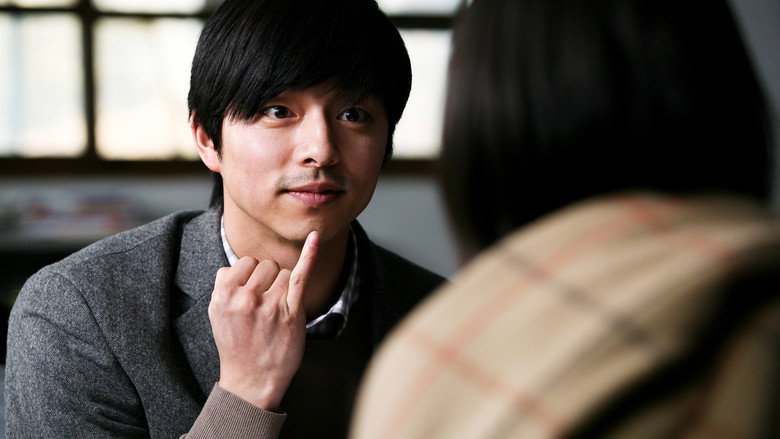 A classroom scene, the camera focused on a young girl sitting alone, her expression hollow, her hands pressed tightly over her ears.