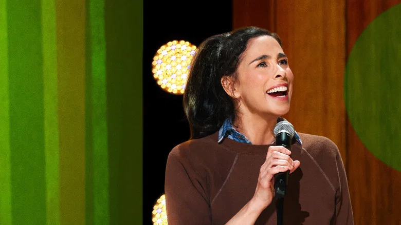 Silverman on stage at the Beacon Theater, mid-gesture, her face caught between a grin and something more complicated