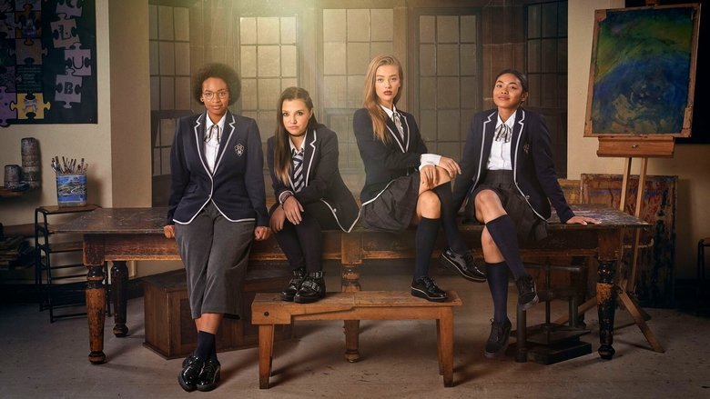 Four girls in school uniforms huddle in a dimly lit room, their faces illuminated by the glow of a laptop screen.
