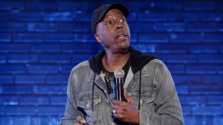 Arsenio Hall on stage, mid-laugh, arms outstretched, bathed in warm light