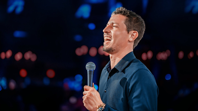 Tony Hinchcliffe mid-roast, standing in the center of a circular stage, surrounded by audience members who look more confused than amused