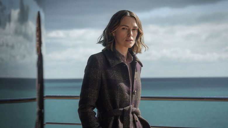 A close-up shot of Lo Blacklock in a dimly lit, luxurious stateroom, looking fearful