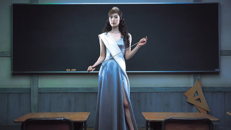 A darkened classroom, the only light coming from the hallway, casting long shadows as Maya Akutsu stands at the front, her black dress absorbing the dim glow