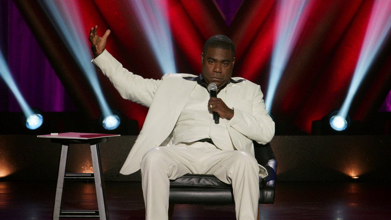 Tracy Morgan on stage, bathed in warm light, mid-laugh as he gestures to the audience