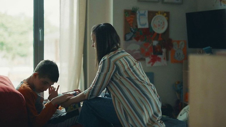 A dimly lit living room, the glow of a lamp casting long shadows. Antoine sits on the floor, his hands moving rhythmically over a toy car, while Julie watches from the doorway, her expression unreadable.