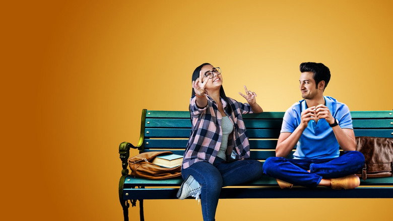 Dimple and Rishi sitting on a rooftop at night, the city lights blurred behind them, their faces half in shadow as they talk
