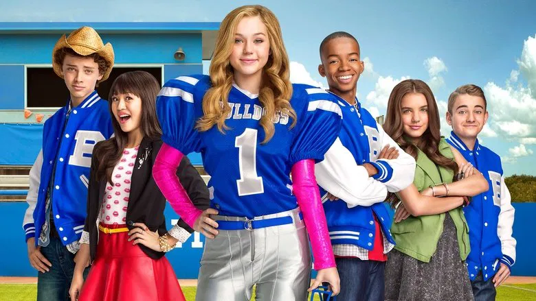 Bella Dawson in her cheerleader uniform, mid-throw, with a football spiraling toward the camera