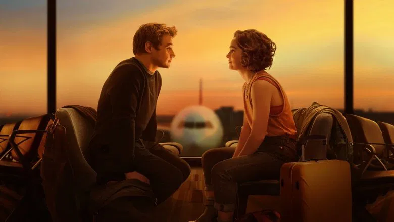 Hadley and Oliver share a quiet moment in the airport terminal, their faces lit by the soft glow of overhead lights.