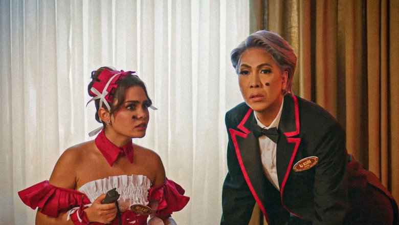 A chaotic scene with Vice Ganda and Ivana Alawi in a brightly lit, overcrowded room, their expressions a mix of confusion and forced amusement.