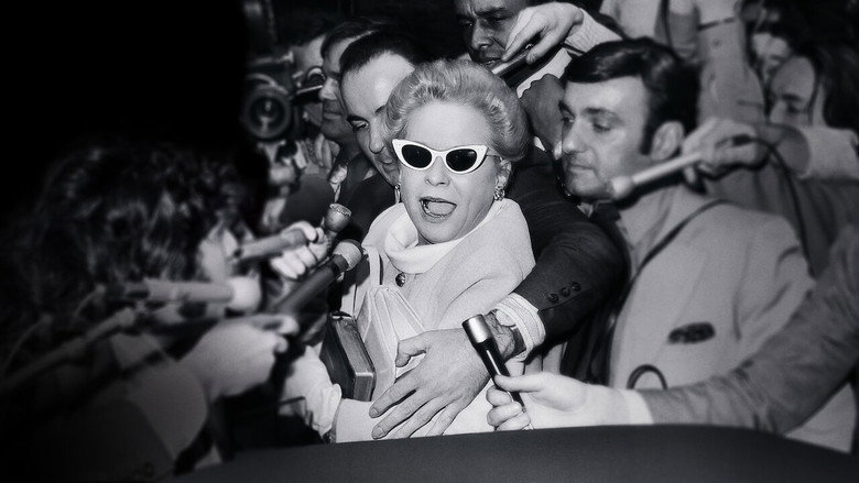 A grainy archival shot of Martha Mitchell mid-conversation, her expression a mix of defiance and exhaustion