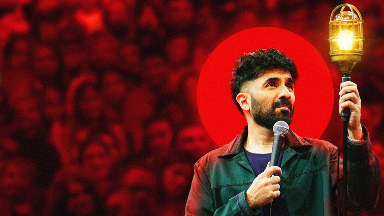 Vir Das on stage in a dimly lit venue, holding a single bulb that casts a warm glow on his face