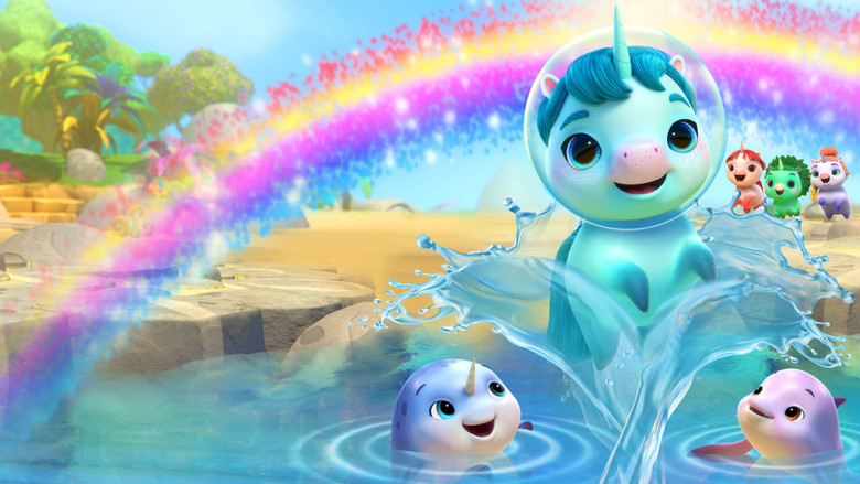 Kelp the unicorn, mid-swim, surrounded by his narwhal family in a sun-dappled ocean