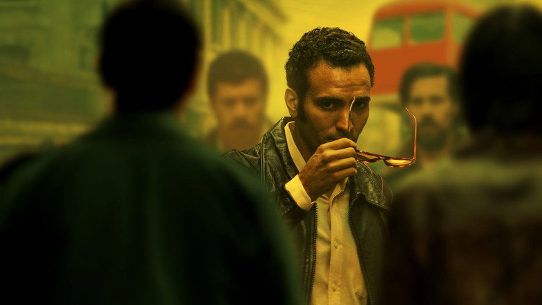 A tense meeting in a dimly lit room, where Ashraf Marwan exchanges classified documents with his Mossad handler.