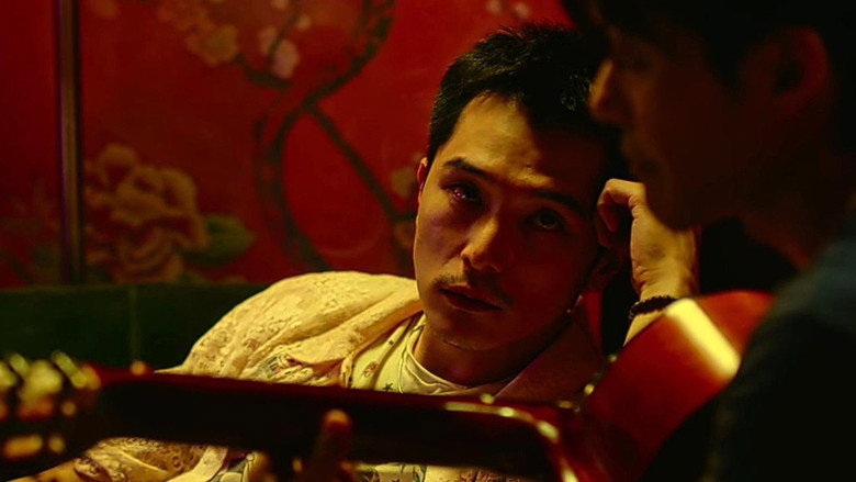 A tense moment between Sanlian and Jay, their faces half-lit by the glow of a lamp, the air thick with unspoken accusations.