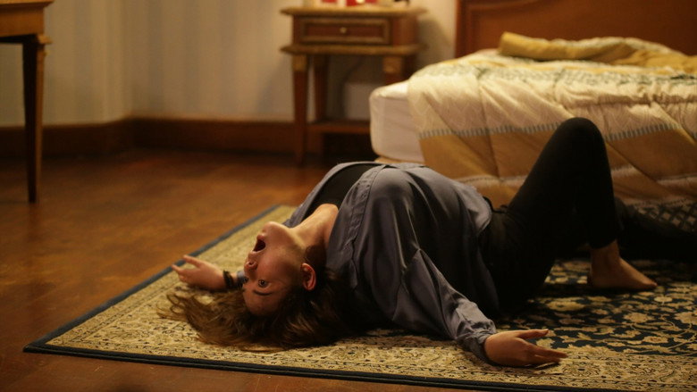 A dimly lit room where Zora, played by Amanda Manopo, stands in the foreground, her face half-shadowed, while a spectral figure looms in the background, barely visible.