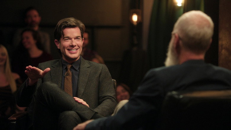 Letterman and Mulaney walking down a high school hallway, the fluorescent lights casting long shadows