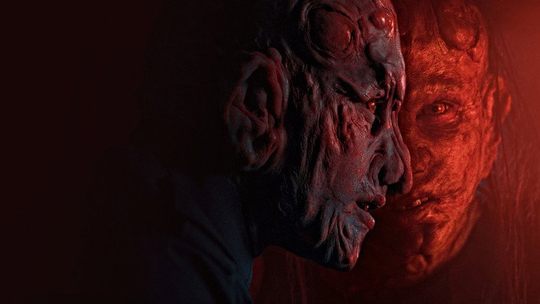 A group of terrified characters huddle in a dimly lit cabin, their faces illuminated by the eerie glow of a single light source.