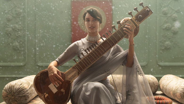 A dimly lit room where a young woman in a white sari sits at a gramophone, her fingers hovering over the needle as if afraid to touch it.