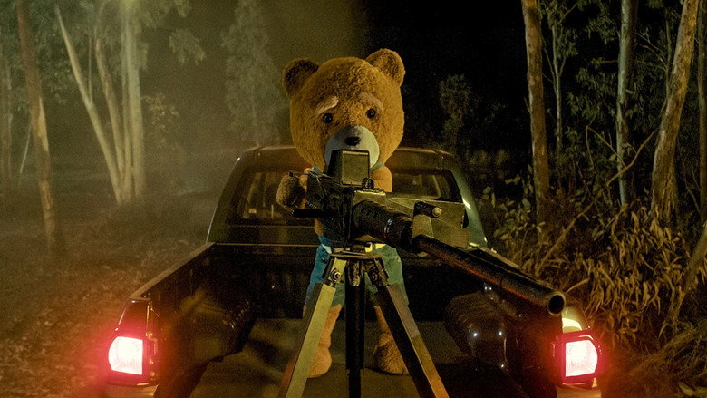 A wide shot of Buddy the teddy bear standing in a dimly lit room, its button eyes glowing faintly as it looks up at the camera.