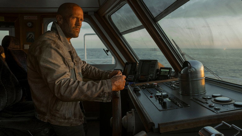A lone figure stands on the deck of a cargo ship, the ocean stretching endlessly behind him, the ship’s rusted metal railing a fragile barrier between him and the abyss.