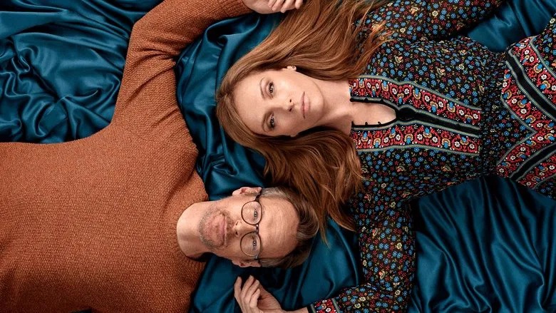 A dimly lit therapy session, Joy and Alan sitting on opposite ends of a couch, their bodies angled away from each other
