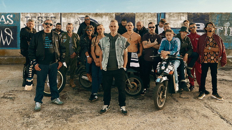 A dimly lit alleyway in Naples, where Sandro and his crew gather under the glow of a single streetlamp, the tension palpable even in stillness.