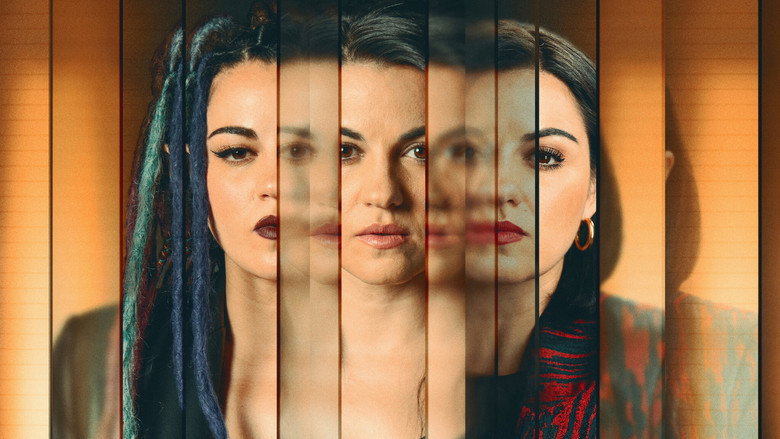 A dimly lit room where three women stand in a triangle, their faces half in shadow, their expressions unreadable