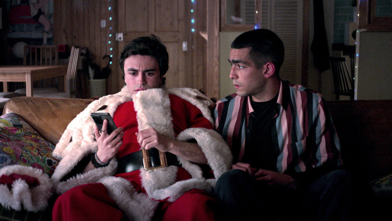 Samuel and Omar sit on a bed, the dim light casting long shadows across their faces as they stare at a laptop screen.