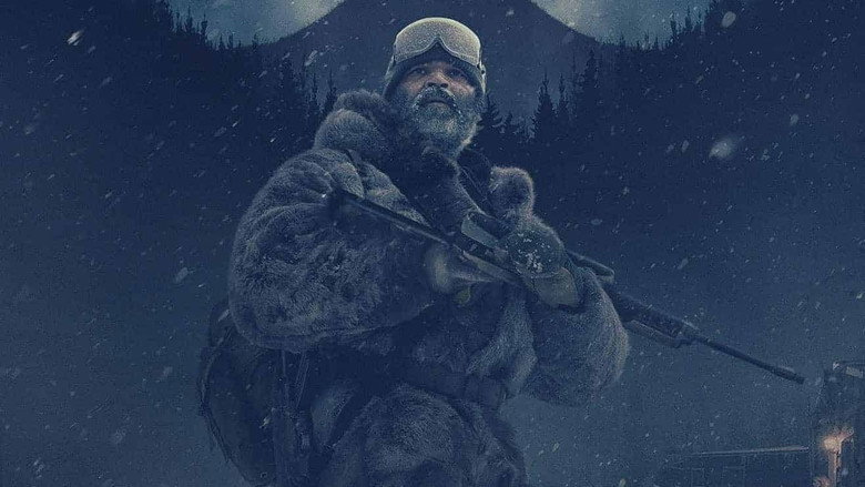 Russell Core stands in the snow, his breath visible in the frigid air, the vast Alaskan wilderness stretching behind him.
