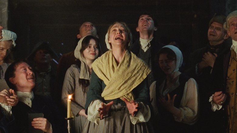 A close-up of hands working on a spinning wheel in dim light