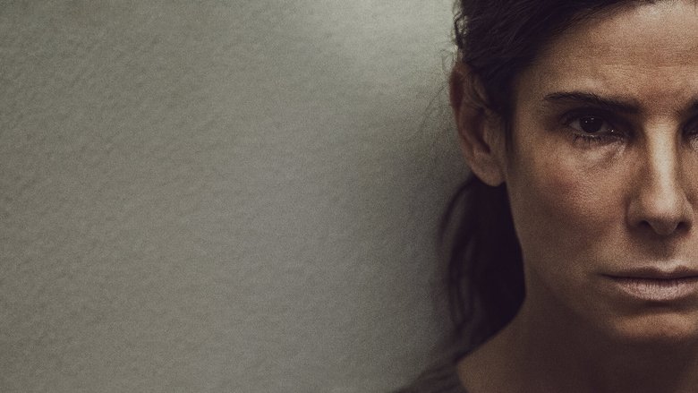 A woman in a dimly lit room, her face half in shadow, staring at her reflection in a foggy mirror
