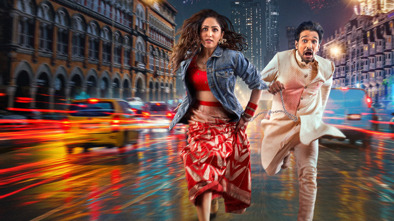 A neon-lit Mumbai street at night, the camera tilted to emphasize the disorientation of the chase, with Yami Gautam Dhar and Pratik Gandhi caught in the headlights of an oncoming car.