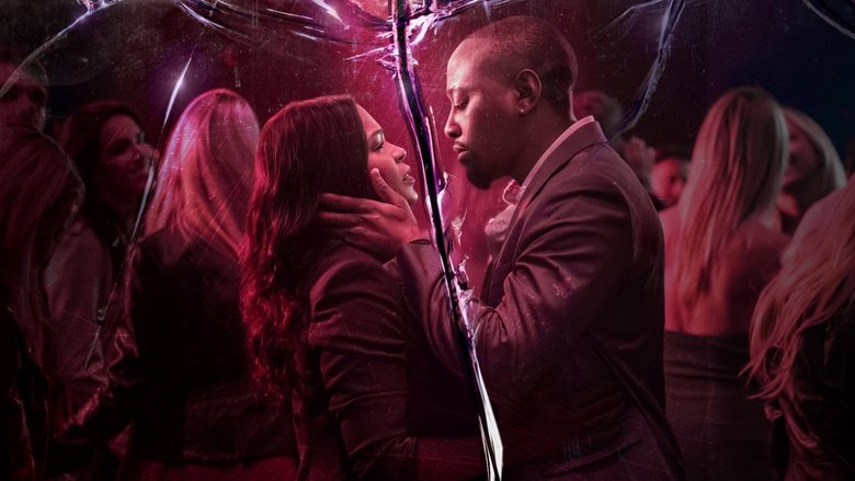 A tense confrontation in a dimly lit room, shadows stretching across the walls as Ellie Warren (Nia Long) faces her tormentor.