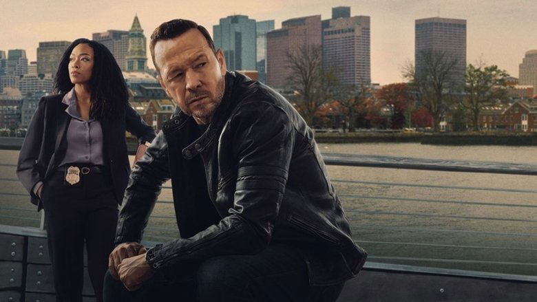 A shadowed view of a Boston intersection at dusk, capturing the city's stark architectural contrast.