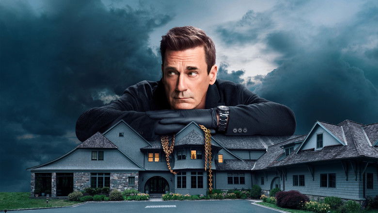 A silhouette of a man standing at a floor-to-ceiling window, looking out over a darkened, quiet suburban street.