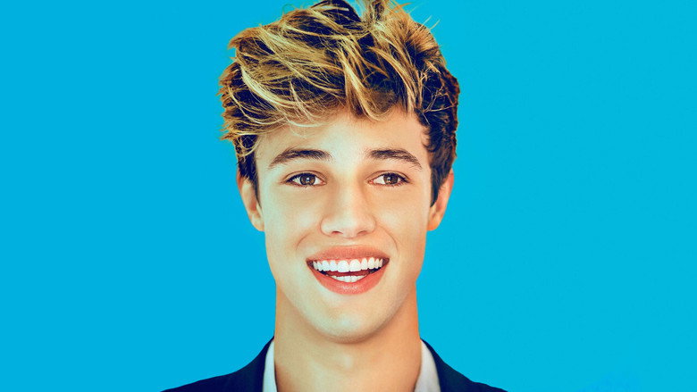 Cameron Dallas adjusting his reflection in a mirror, the camera capturing both his face and its own lens